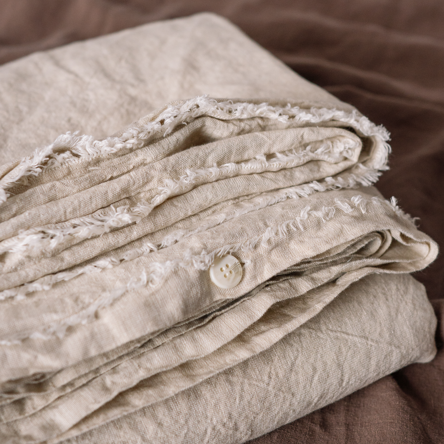 Sandy color Lewisii linen duvet cover detail photo with buttons and fringe edges