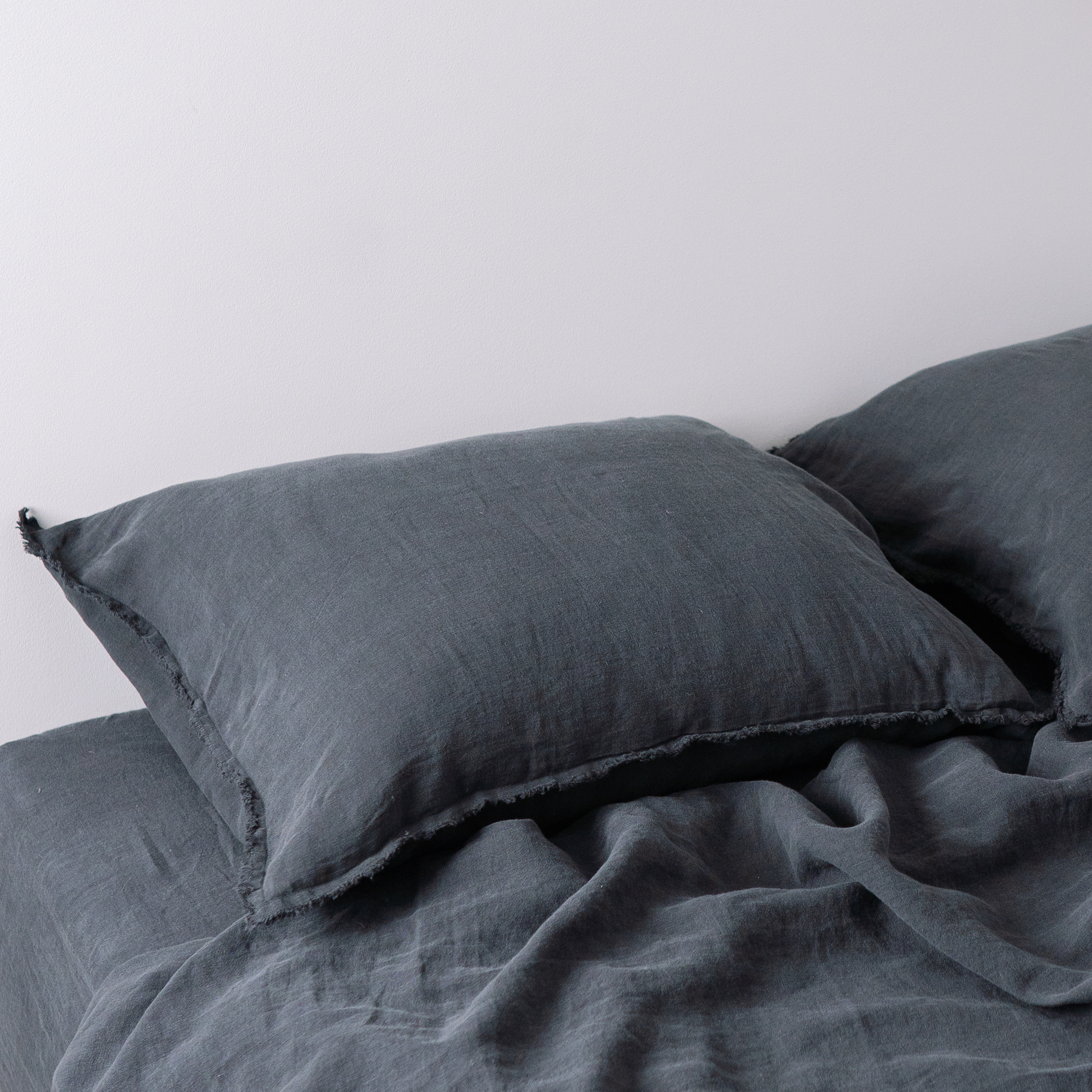 Two pillows in LEWSII pillowcases in Dark Grey color
