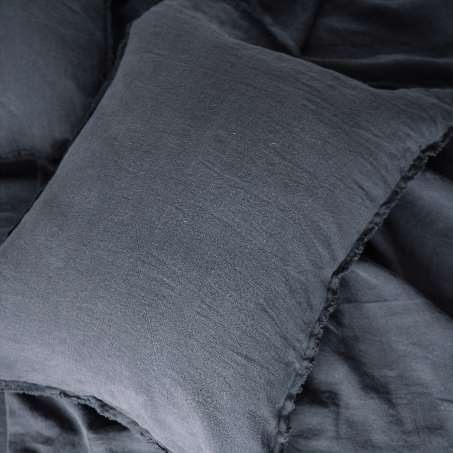 A closeup of a LEWSII pillowcase in color Dark Grey
