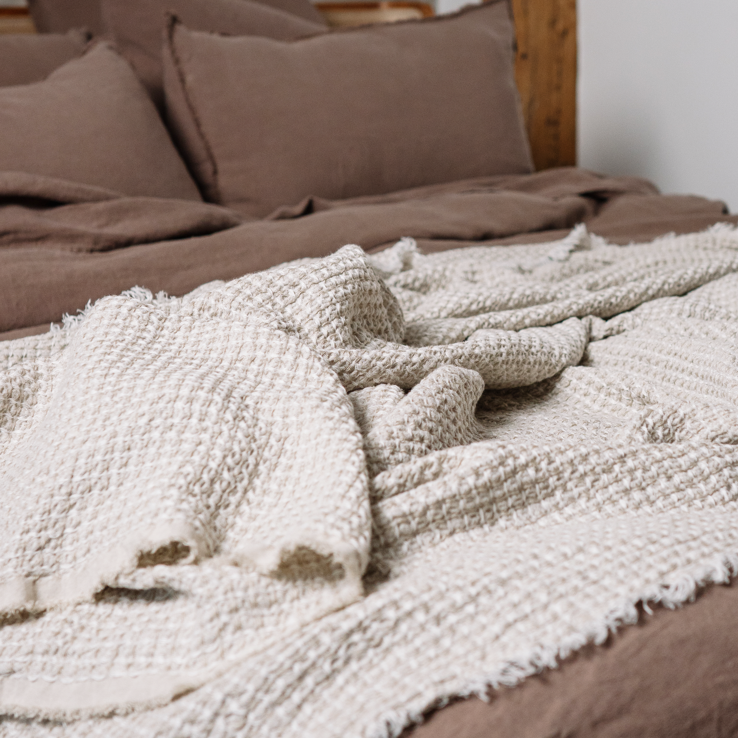 Linen waffle blanket in sandy color close up photo on bed