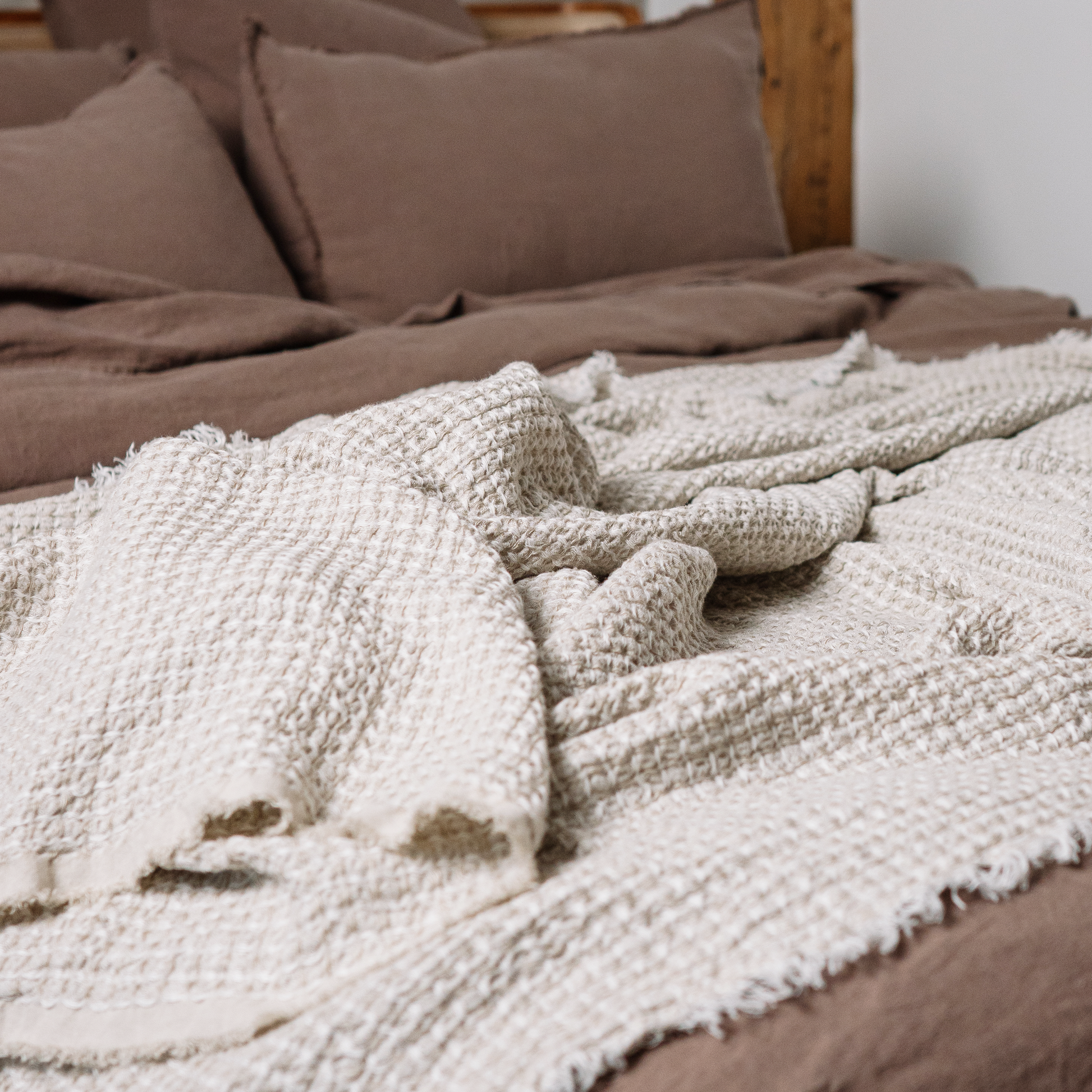 Linen waffle blanket in sandy color close up photo on bed