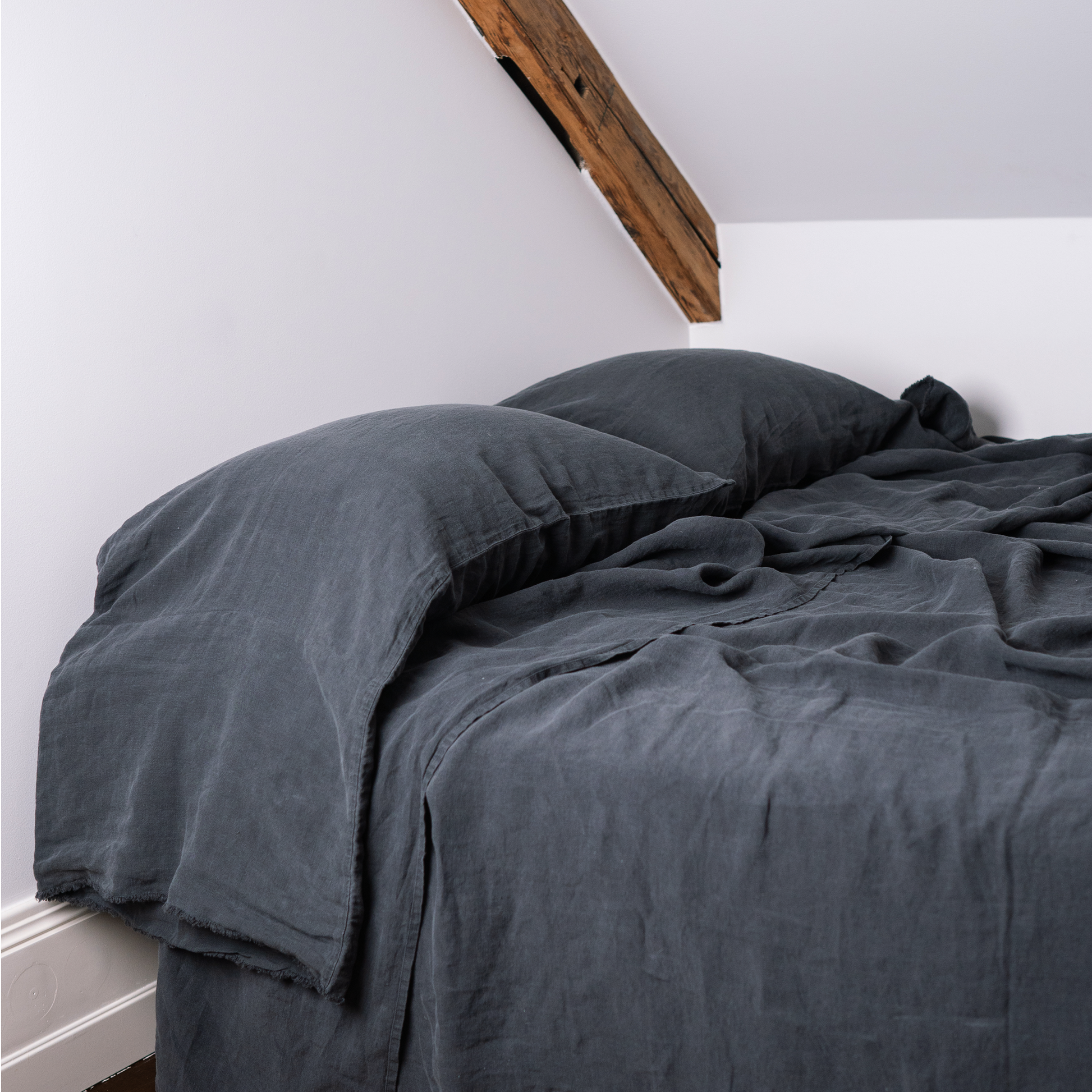 Bed with two long linen pillowcases in color Dark Grey