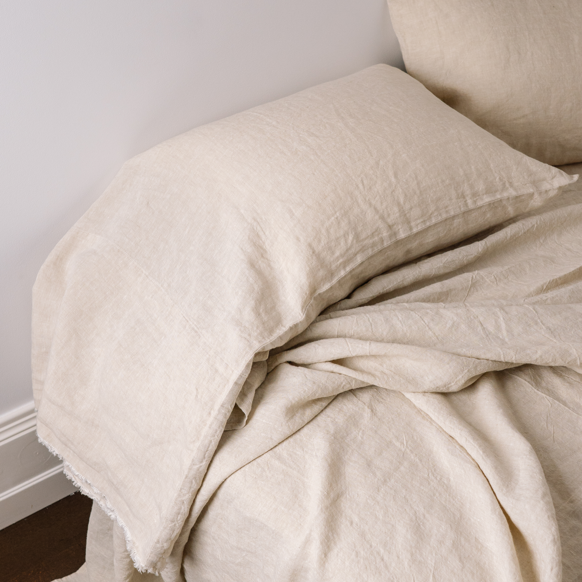 A closeup of a long linen pillowcase in color Sandy 